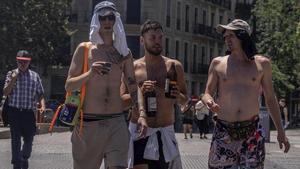 Tres joves es passegen amb el tors descobert a Barcelona, ahir.  | JORDI OTIX