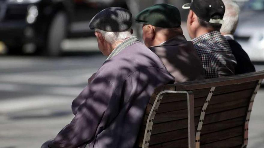 Varios hombres conversan en un banco.