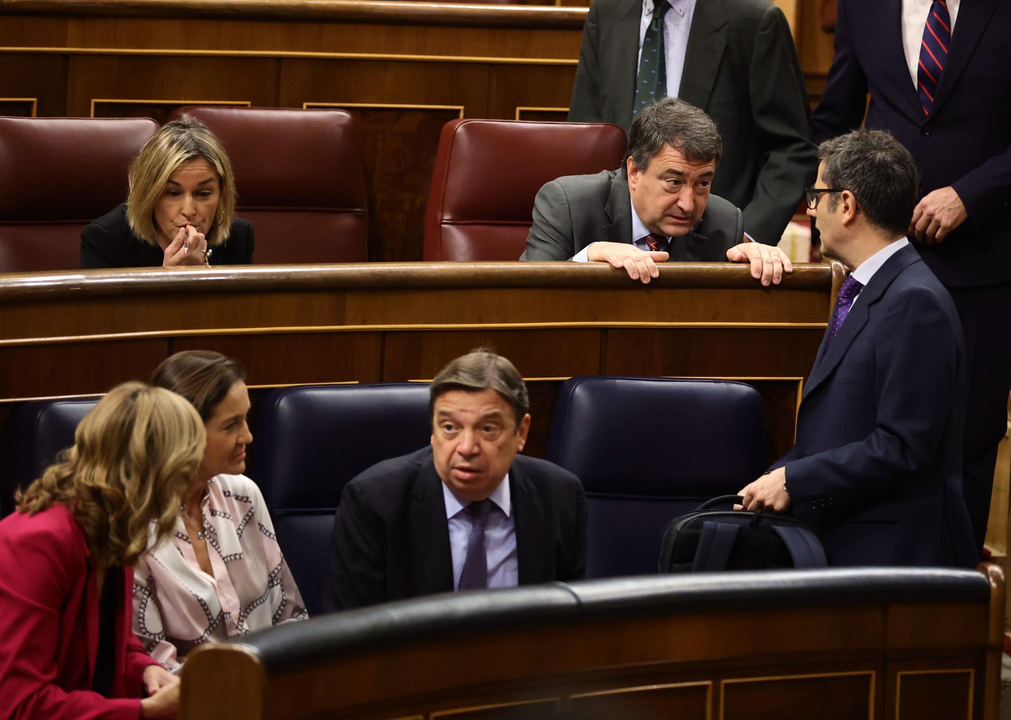 El portavoz del PNV en el Congreso de los Diputados, Aitor Esteban (c), y el ministro de Presidencia, Relaciones con las Cortes y Memoria Democrática, Félix Bolaños (d), conversan en una sesión de control, en el Congreso de los Diputados, a 11 de mayo de 2022.