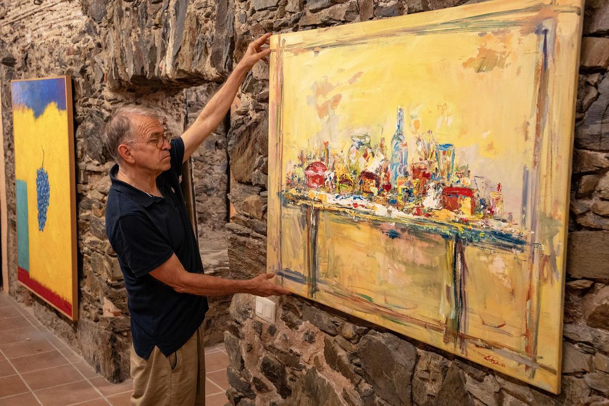 Josep Playà amb una de les obres de Patxé que es poden veure a l'exposició a Garriguella.