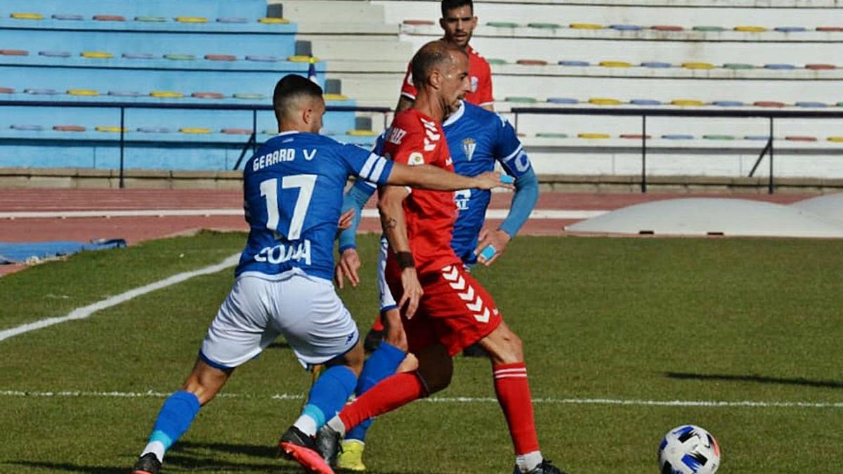 David González ejecuta un pase ante la presión de dos jugadores del San Fernando, en un lance del partido de ayer en Cádiz.
