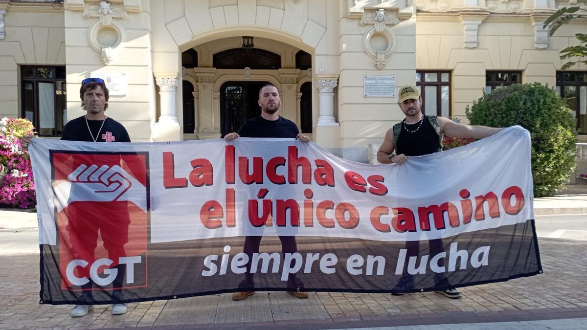 Tres de los socorristas del comité de huelga despedidos, delante del Ayuntamiento, este lunes.
