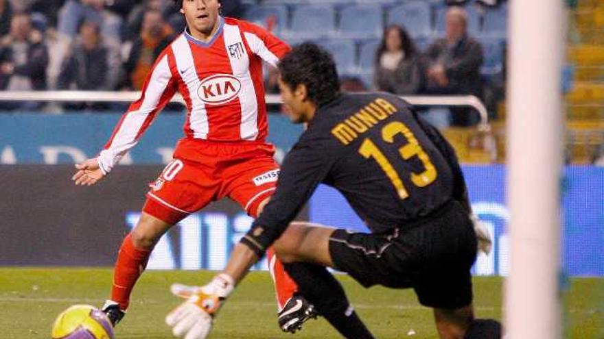 El delantero argentino del Atlético de Madrid Sergio Agüero bate al portero uruguayo Gustavo Adolfo Munúa, del Deportivo, en el segundo gol de su equipo el pasado domingo