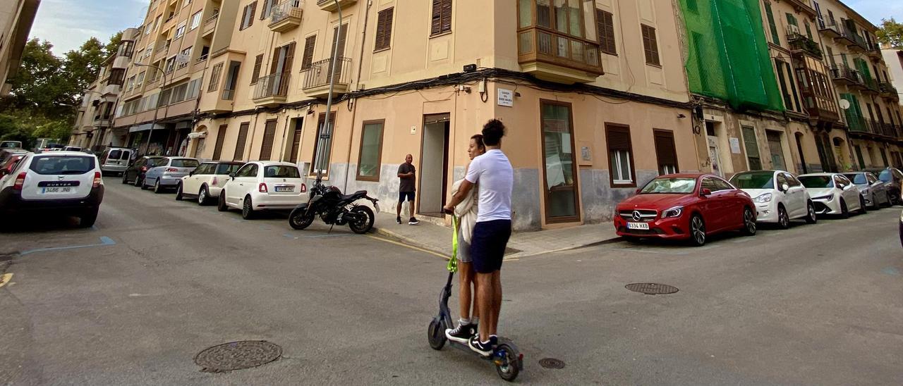 Una pareja en patinete circula por la calle Margarita Caimari de Palma