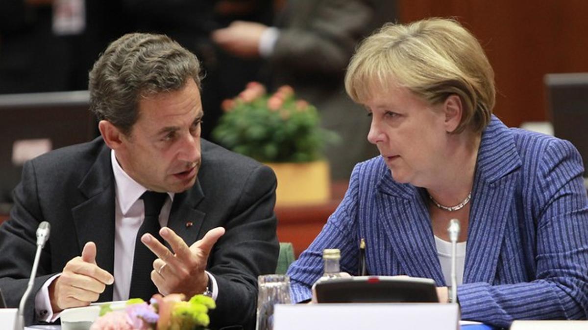 El presidente francés, Nicolás Sarzkoy, conversa con la cancillera alemana, Angela Merkel, al comienzo de la cumbre de jefes de estado de la UE que se celebra en Bruselas.