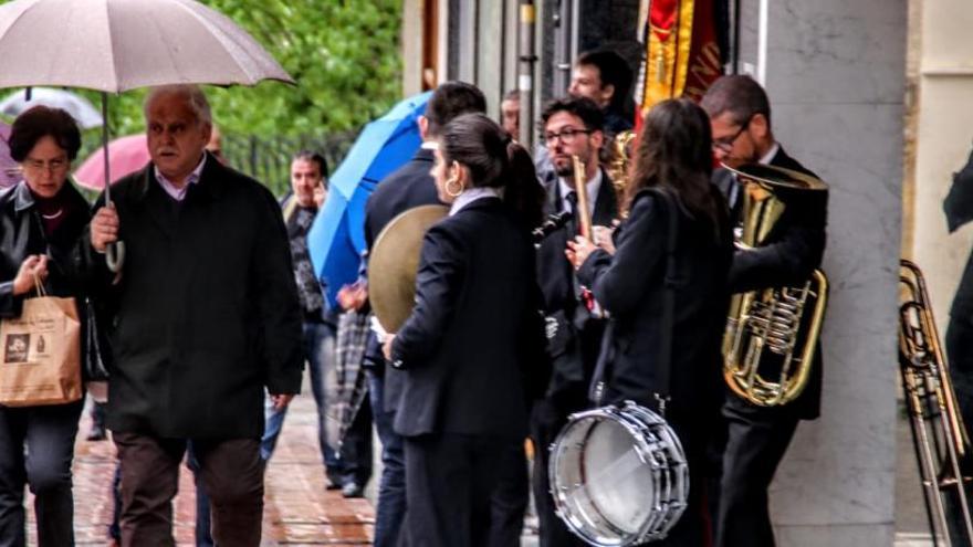 Un grupo de músicos resguardándose de la lluvia en la avenida País Valencià