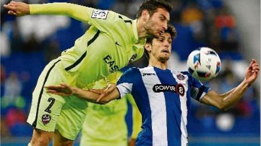 Ivan López, exjugador del Girona ara al Llevant, pugnant per la pilota amb Gerard Moreno.