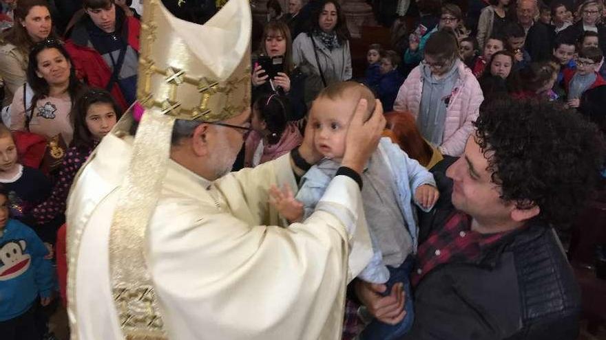 El arzobispo de Oviedo, Jesús Sanz, bendice al niño Jesús Martínez en la basílica de Covadonga, ayer.