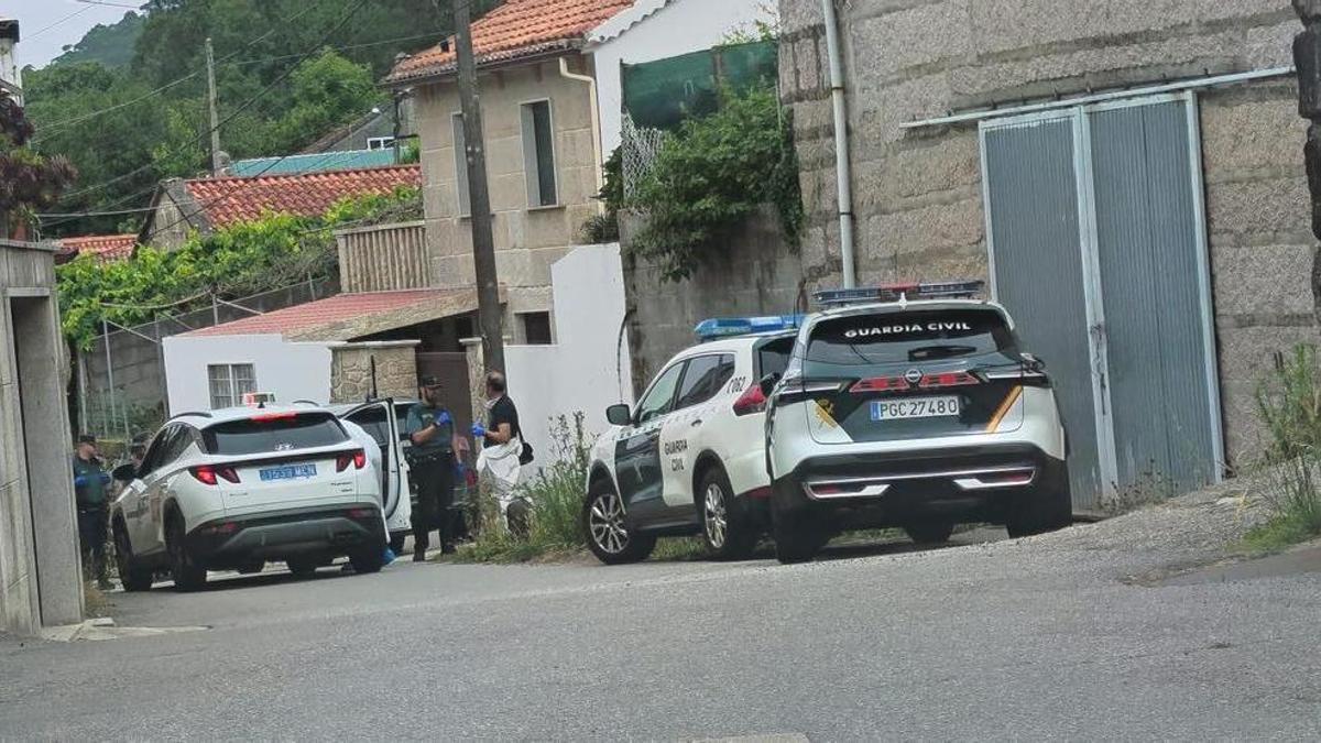 Guardia Civil en el lugar de A Portela junto a la vivienda de la mujer fallecida, a la izquierda.