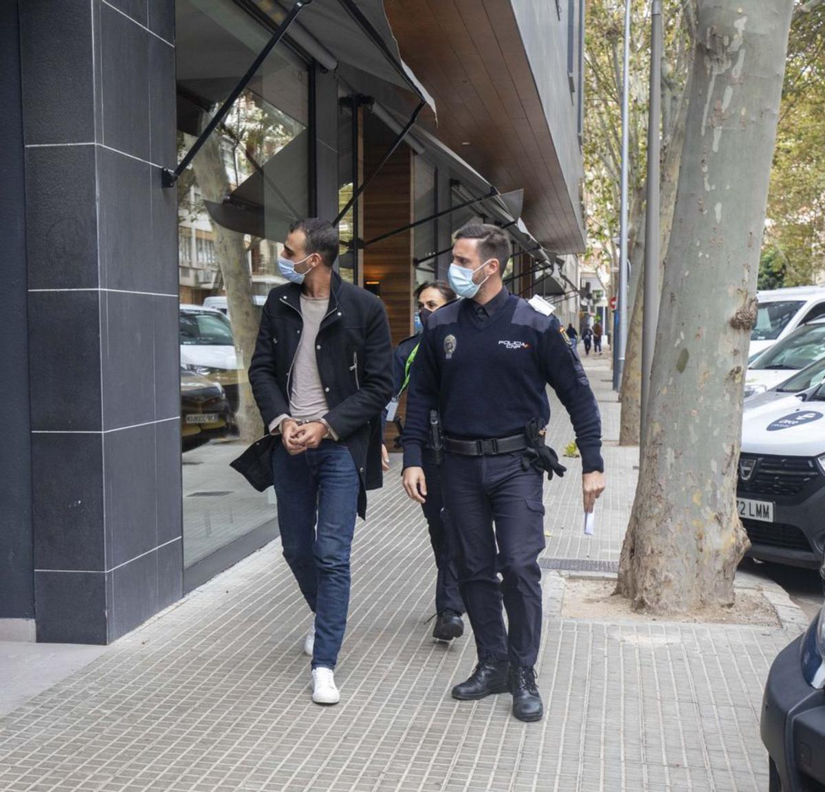 Varios policías, junto a un migrante arrestado.