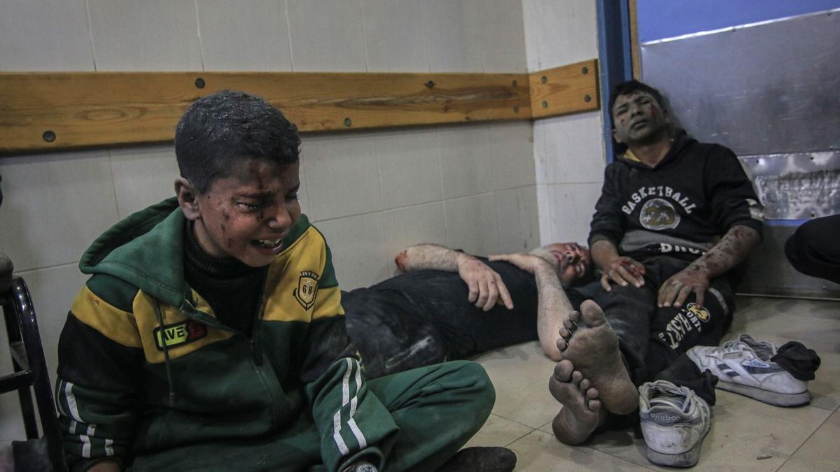 Tres palestinos heridos durante el bombardeo israelí en Jan Yunis aguardan a ser atendido en el suelo del hostpial Nasser, este viernes.