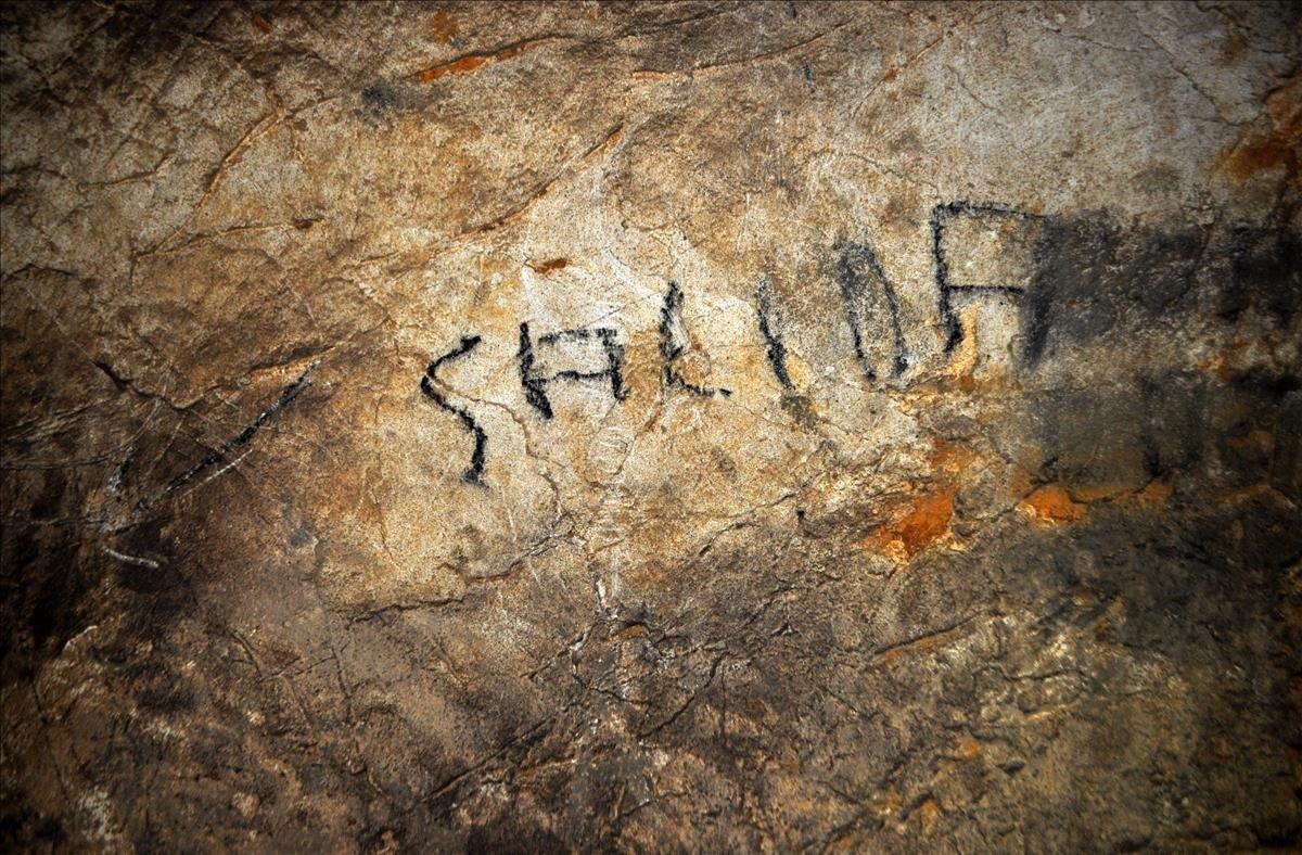 Un grafiti con la palabra ’Salida’ tapa otro de las muestras de arte rupestre halladas en el yacimiento