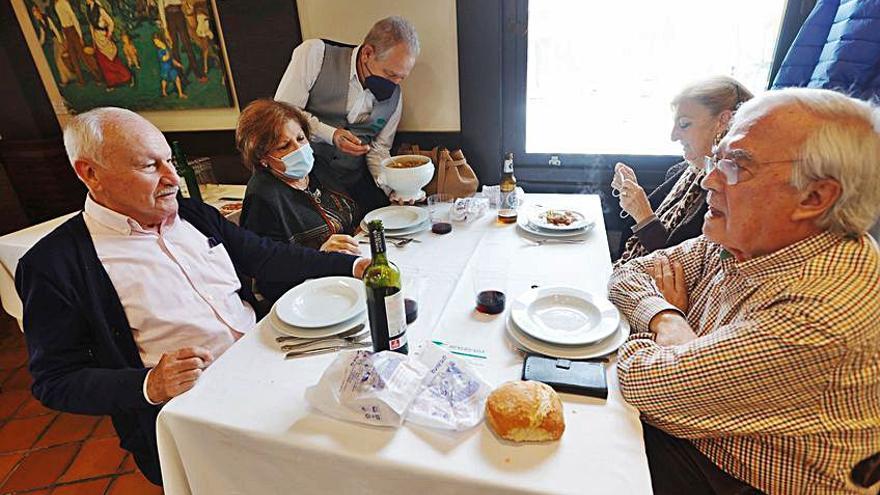 El camarero Manolo Pita sirve el menú de la Ascensión a, por la izquierda, Jesús Taborcías, María Luisa Velasco, Pepi Velasco y Evaristo Arce. | Miki López
