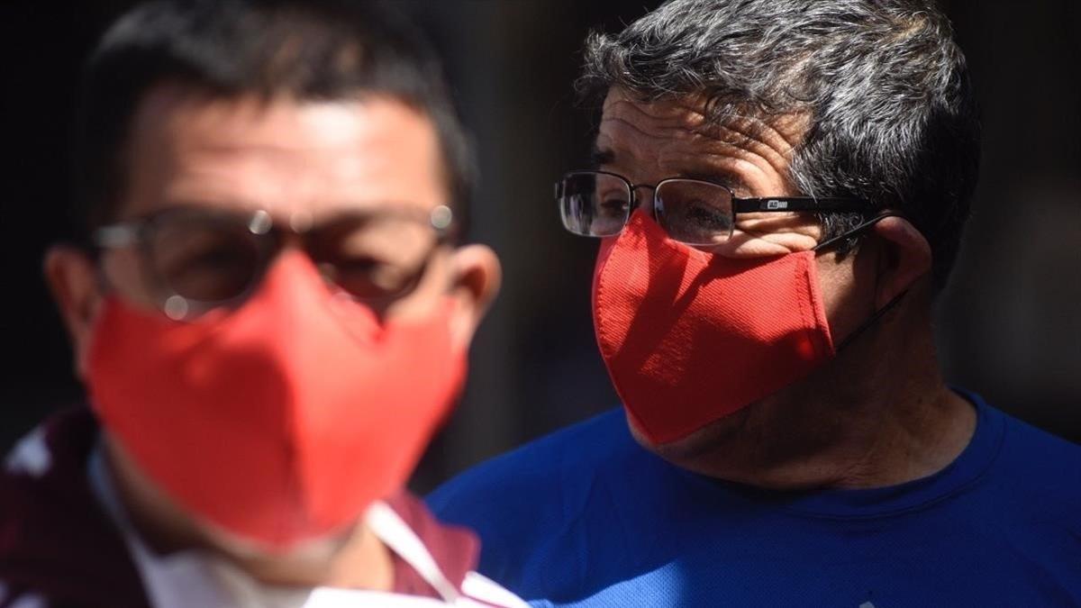 Fotografía cedida por la Gendarmeria de Chile que muestra a reclusos de la carcel de Santiago (Chile)  con las mascarillas que sus propios companeros fabricaron.