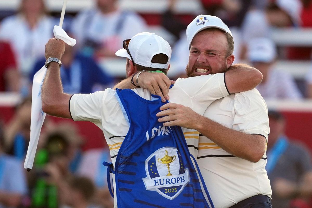 Lowry celebra con su caddy el medio punto que permitia retener la Ryder