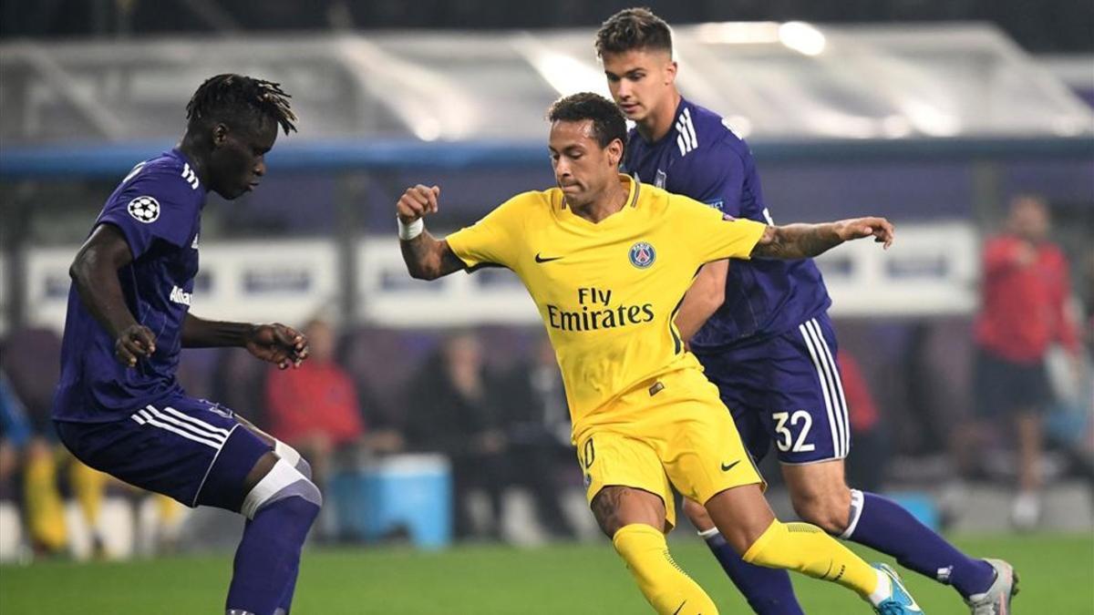 Neymar conduce un ataque del PSG entre dos jugadores del Anderlecht