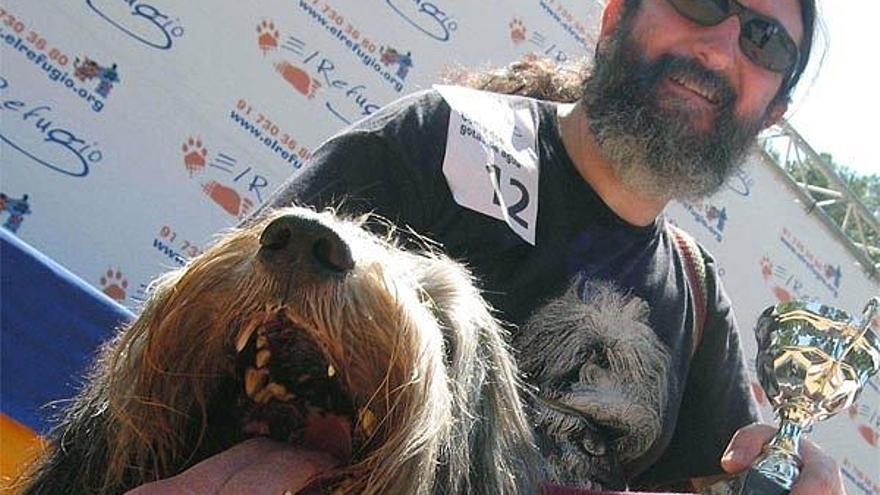 Julio y su perro Nico posan con el trofeo tras quedar en segundo lugar en el XII Festival canino y felino &quot;Como dos gotas de agua&quot;, que premiaba la similitud entre los dueños y los perros y que se ha celebrado hoy en el parque del Retiro de Madrid