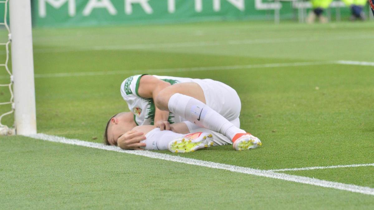 Borja Garcés tirado en el césped con sensibles muestras de dolor, tras sufrir la lesión de rodilla
