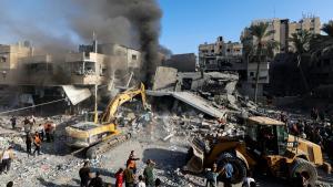 El humo se eleva mientras los palestinos buscan víctimas en el lugar de los ataques israelíes contra un edificio residencial, en medio del conflicto en curso entre Israel y el grupo islamista palestino Hamas, en Khan Younis, en el sur de la Franja de Gaza, el 7 de noviembre de 2023.