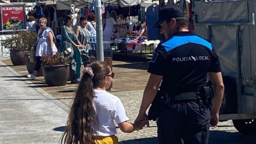 La niña y el policía al que cogió de la mano para pedirle ayuda.