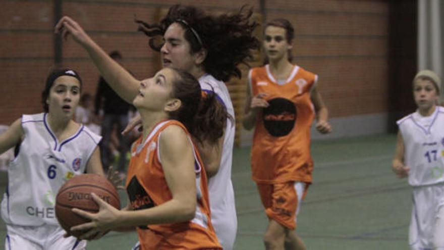 Una de las jugadoras infantiles del Zamarat encara el aro perseguida por una rival.