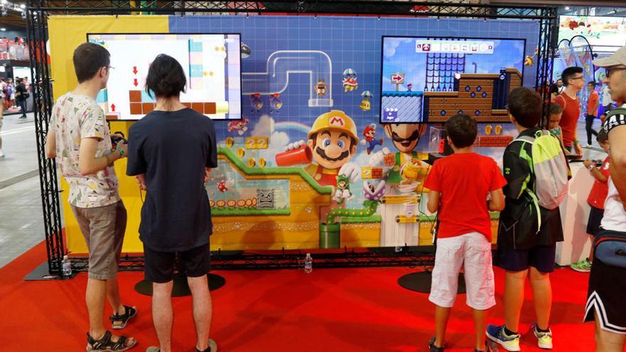 Jóvenes visitantes de Gamepolis, jugando al Mario Bros.