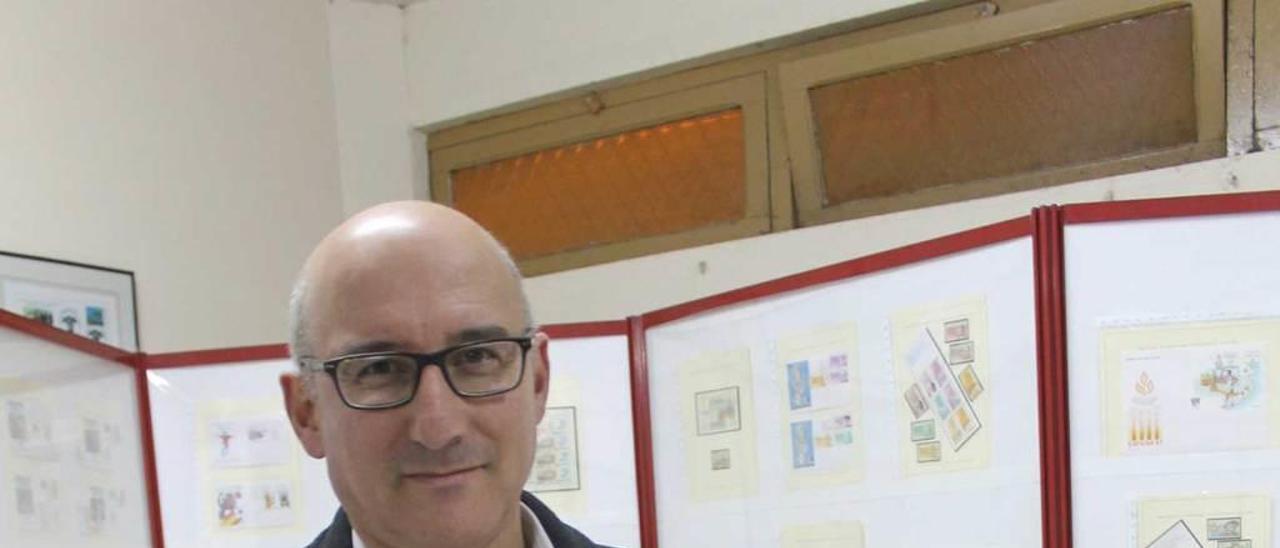 Orlando Pérez Torres con el libro donde guarda los recuerdos filatélicos dedicados a Severo Ochoa. A la derecha, de arriba abajo, una carta del Nobel enviada a Luarca, el primer sello con su retrato, emitido en 1994, y una tarjeta entero postal china con su imagen.