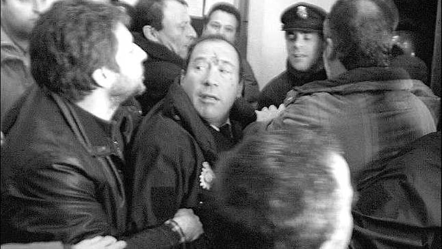 En el centro de la imagen, el policía con heridas en el rostro tras la agresión