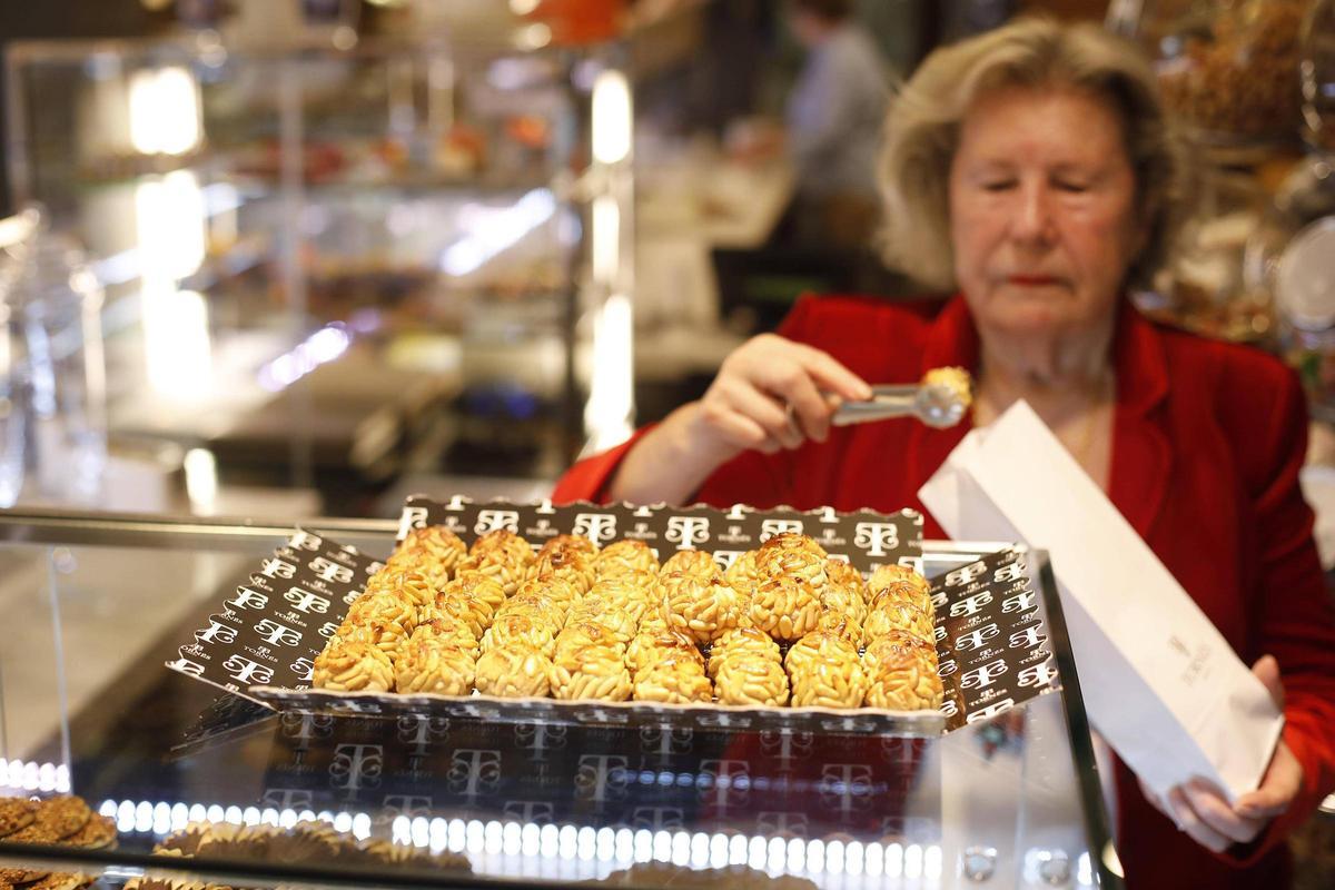 Enriqueta Dalmau servint panellets de pinyons.