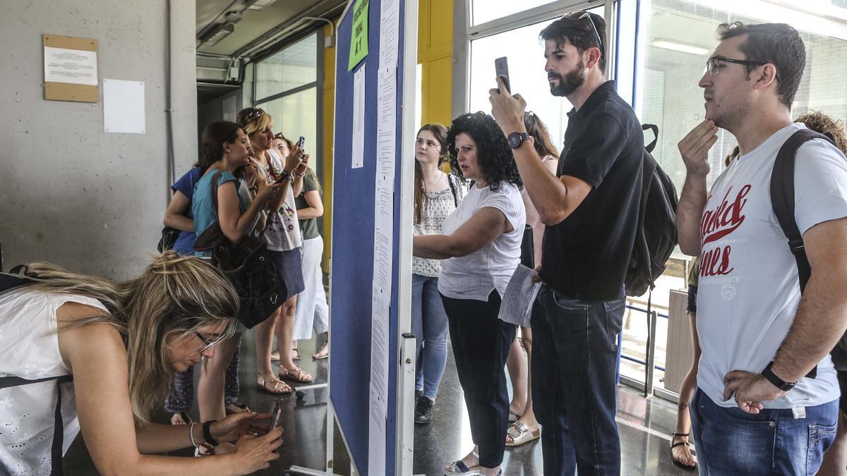 Interinos comprobando su nombre en los listados en una oposició anterior