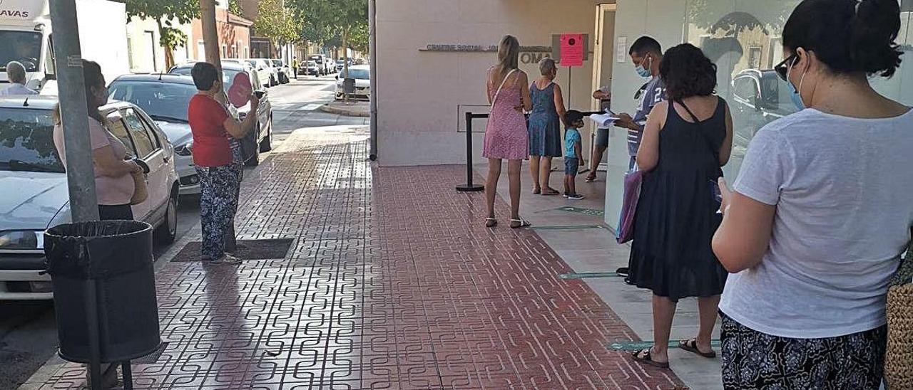 Vecinos aguardan a ser atendidos a las puertas de un edificio municipal de Mutxamel.