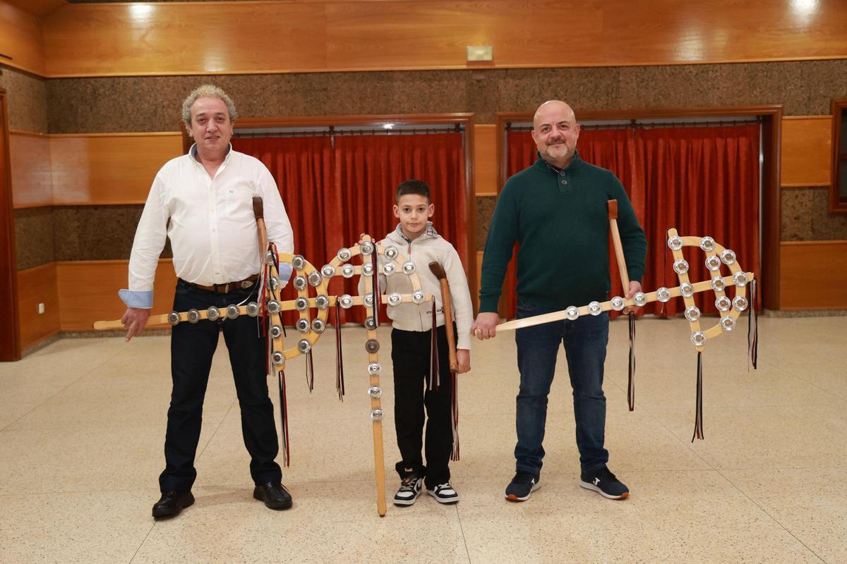 Manuel Bastos, Daniel Fernández e Iago Rodríguez, «rondalleiros» de Chaín empuñan o cristo ou cruz.