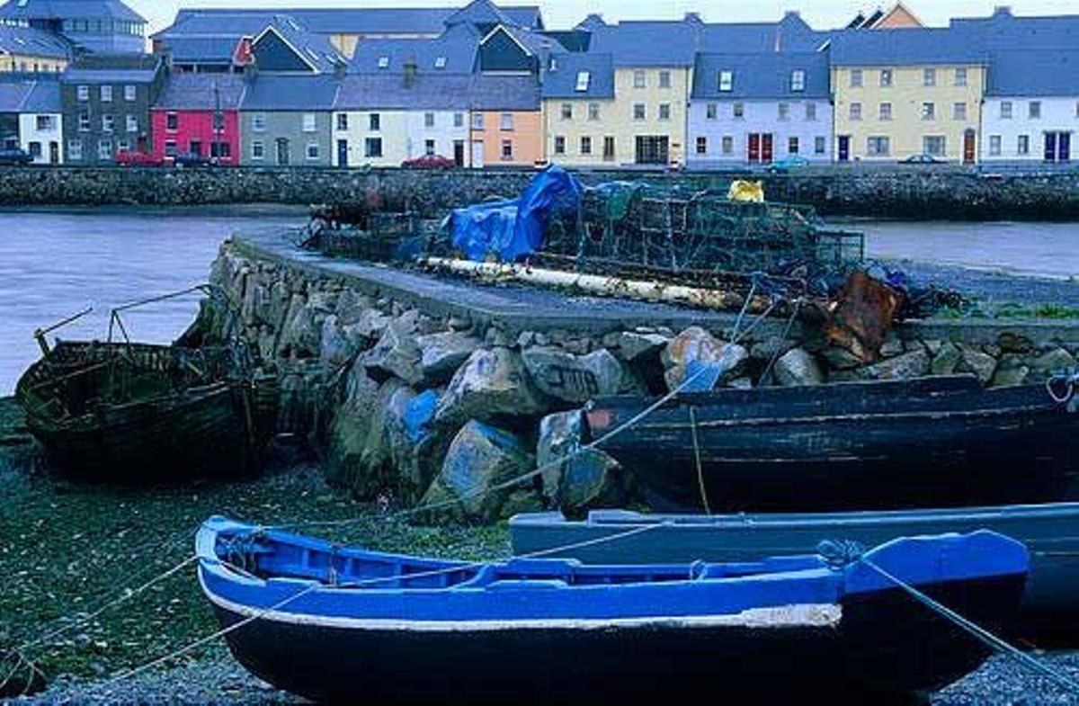 Barco con coloridas casas al fondo en el contado de Galway.