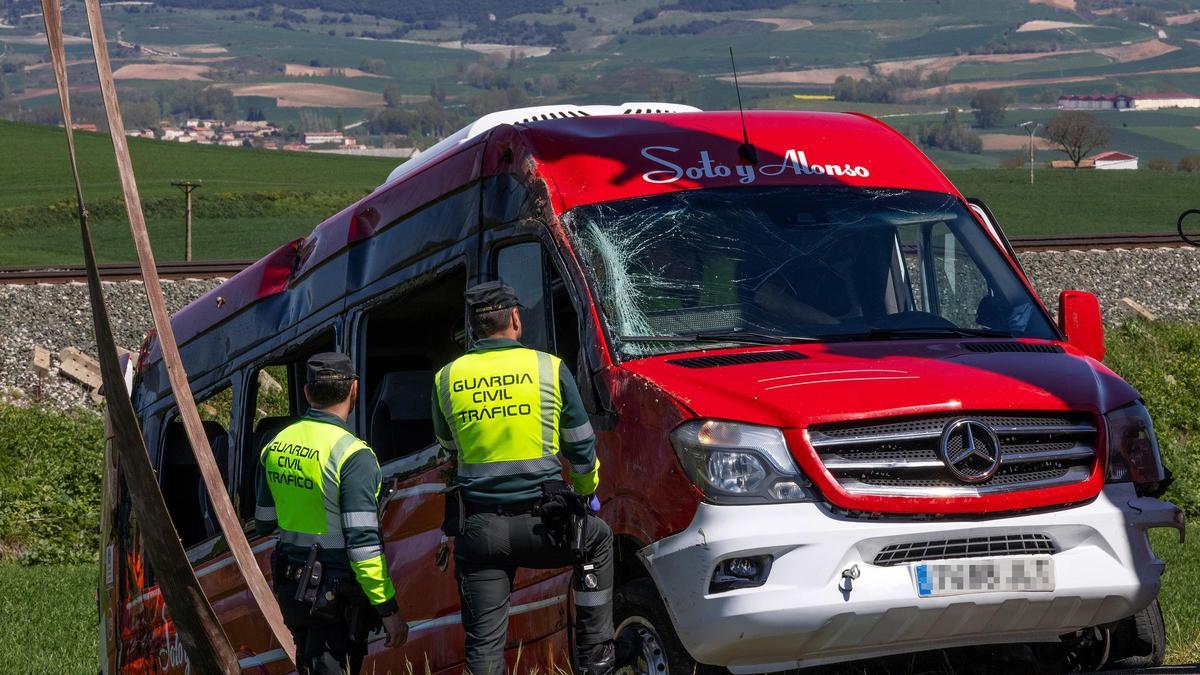 Dos guardias civiles, junto al minibus accidentado.