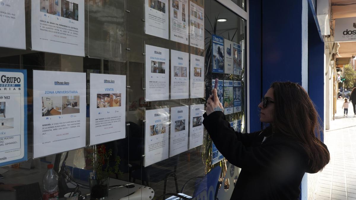 Una mujer consulta los precios de venta de la viviendas en València antes de contratar una hipoteca