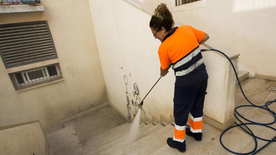 Una operaria baldeando una calle de Alicante