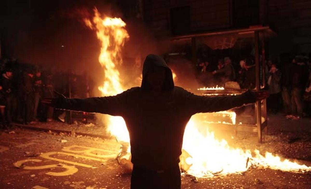 Un manifestant posa davant d’un incendi provocat per altres joves després d’una marxa de milers d’estudiants que protestaven contra els plans governamentals de triplicar les tarifes de matrícula universitària al centre de Londres (Regne Unit).