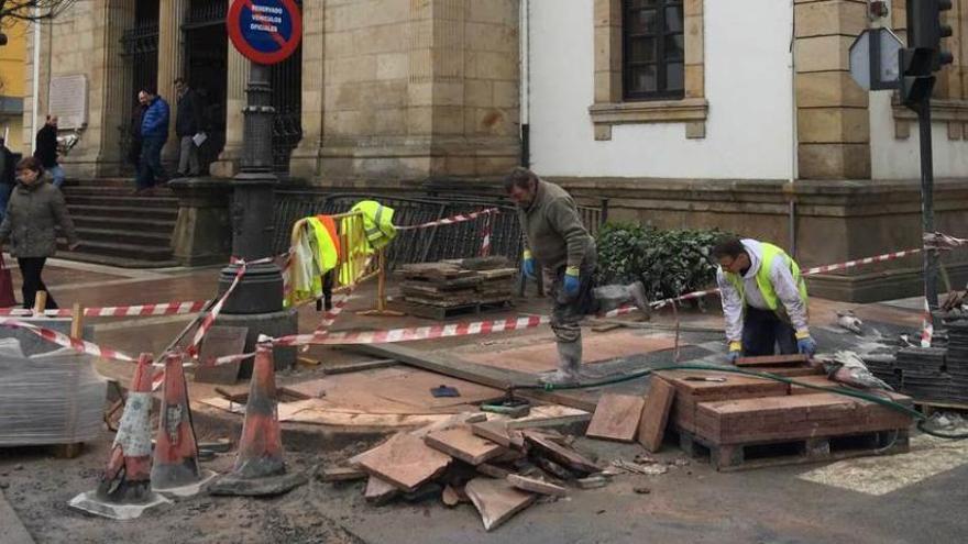 Operarios colocan baldosa rojo Covadonga, ayer.