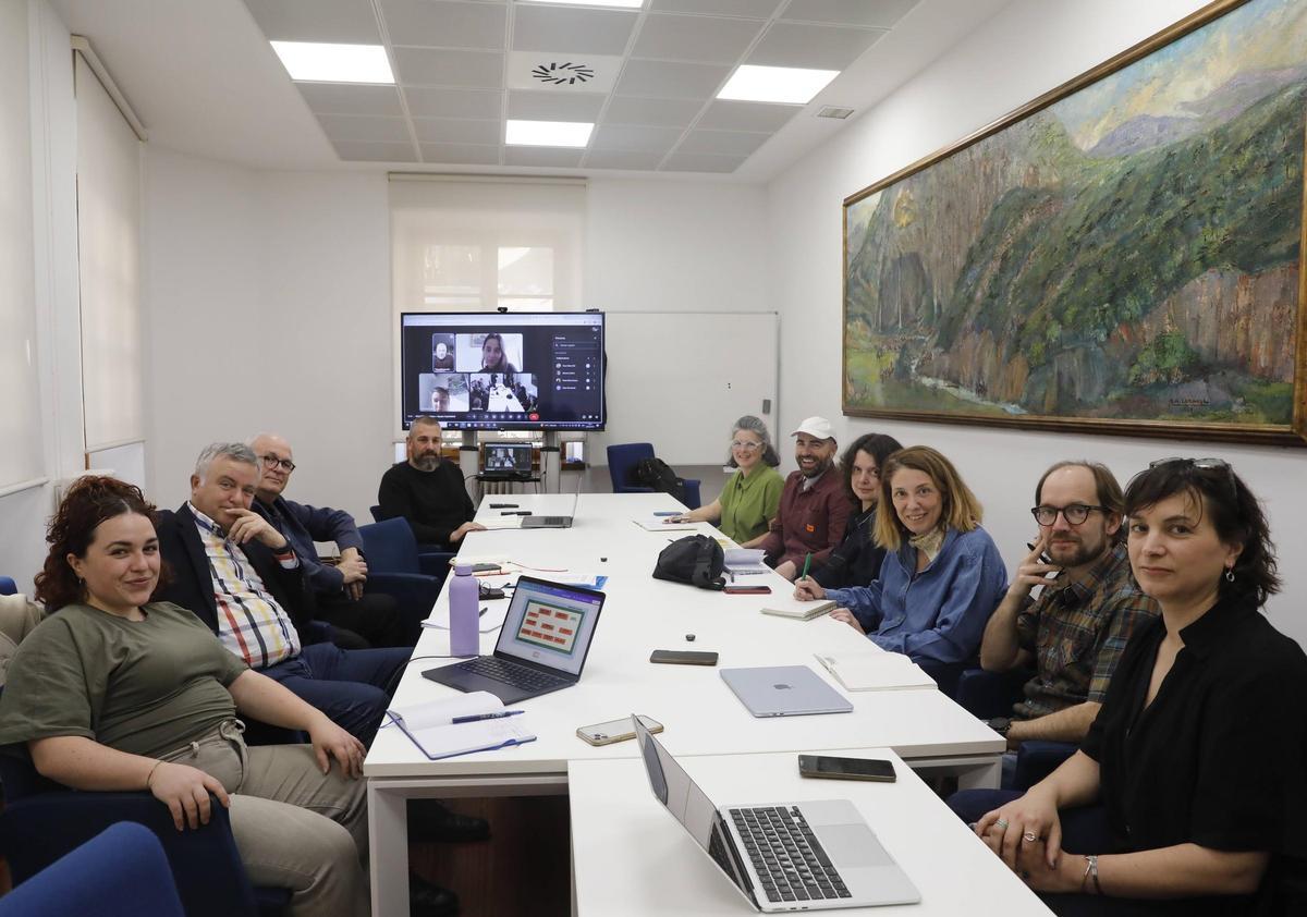 Por la izquierda, en la mesa, Marta Fernández Silverio, Rodolfo Sánchez, Jorge Fernández León y José Castellano, Inés Iglesias, Matteo Mastronardi, Marta Barbón, Ángela Rico, Chus Neira y Zoe López; en la pantalla, Pepe Mompeán, Paula Mota y Mónica Cofiño.