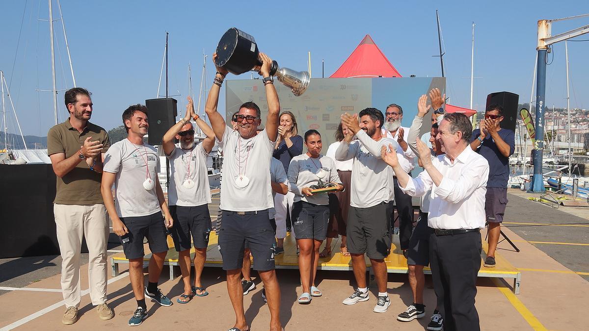 Vicente Cid, patrón del Deep Blue 2.1, levanta el preciado trofeo en la dársena del Náutico junto al resto de la tripulación y el alcalde de Vigo.