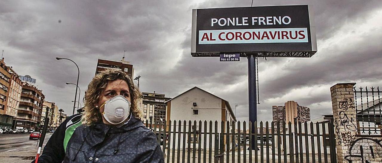 Una mujer con mascarilla de protección en la alicantina avenida de Aguilera, durante los primeros días de la cuarentena.