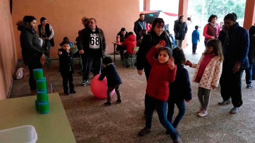 Una niña se dispone a lanzar una bola en uno de los juegos instalados en el pórtico del colegio público.