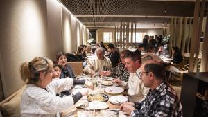 Mesas llenas en el restaurante Divers, en Manresa (Barcelona), donde, en primer plano, una familia que comparte platos.