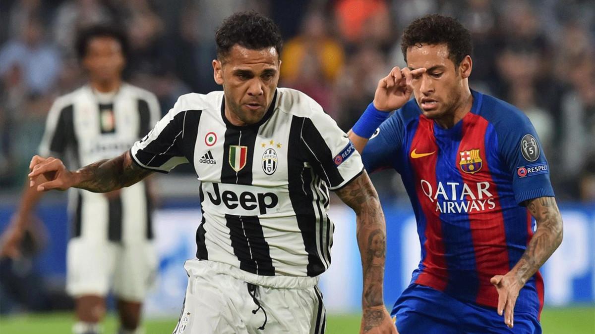 Dani Alves pelea un balón con Neymar durante el Juventus-Barcelona (3-0)