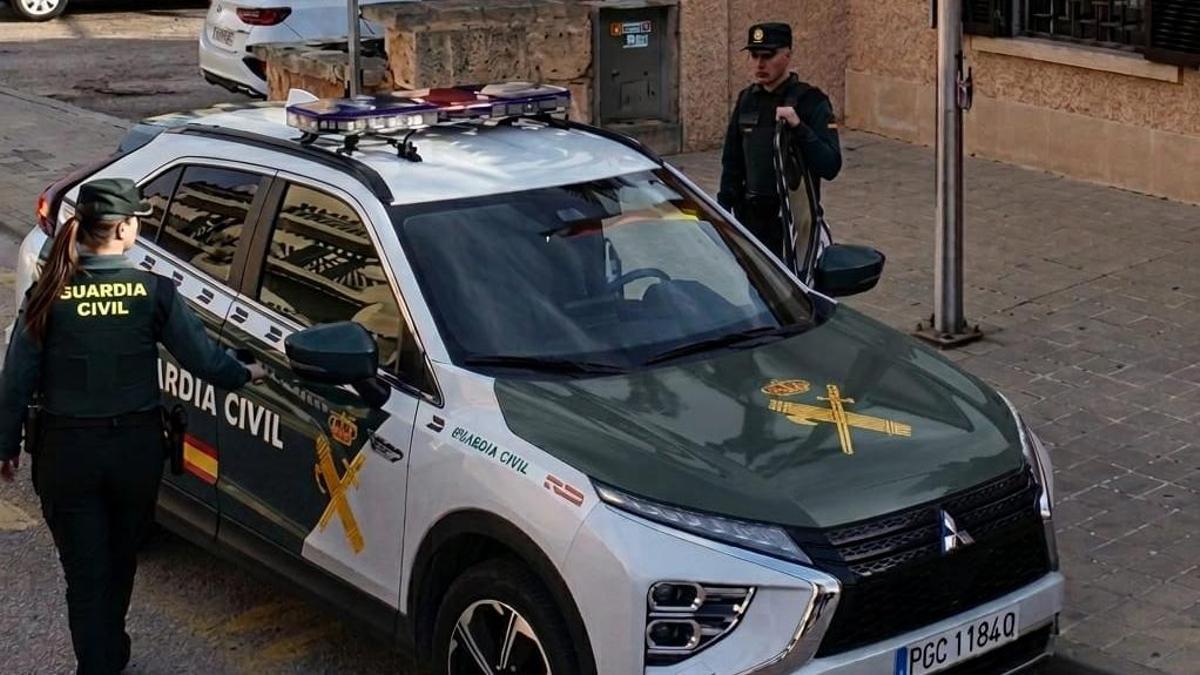 Agentes de la Guardia Civil, junto al coche patrulla.