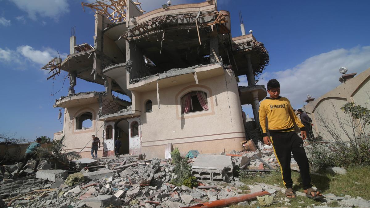 Palestinos frente a un edificio destruido por un bombardeo del Ejército de Israel.