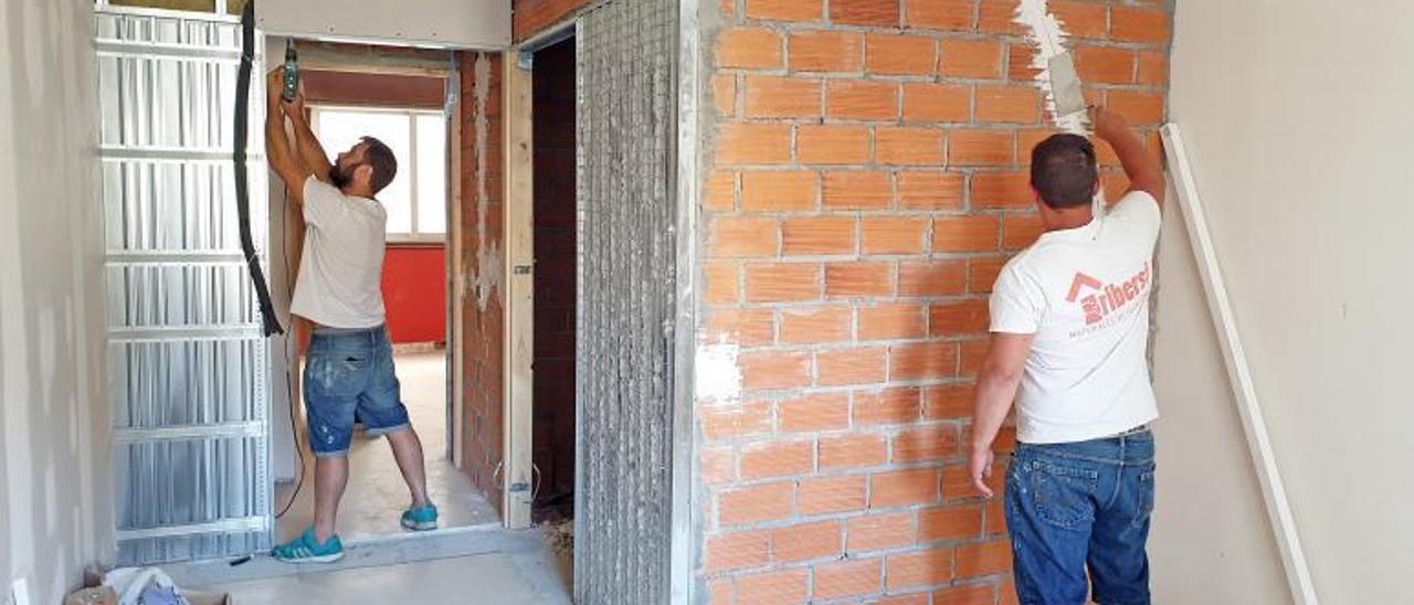 Dos trabajadores, ayer, reformando una vivienda en la calle Venezuela. |   // MARTA G. BREA