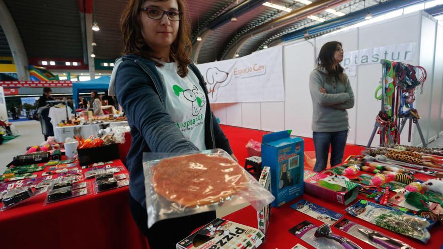 Una voluntaria de una de las protectoras asturianas, con una pizza para perros.