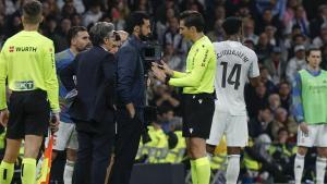 El árbitro Munuera Montero conversa con el técnico del Real Madrid, Álvaro Arbeloa, tras la roja a Fede Valverde.