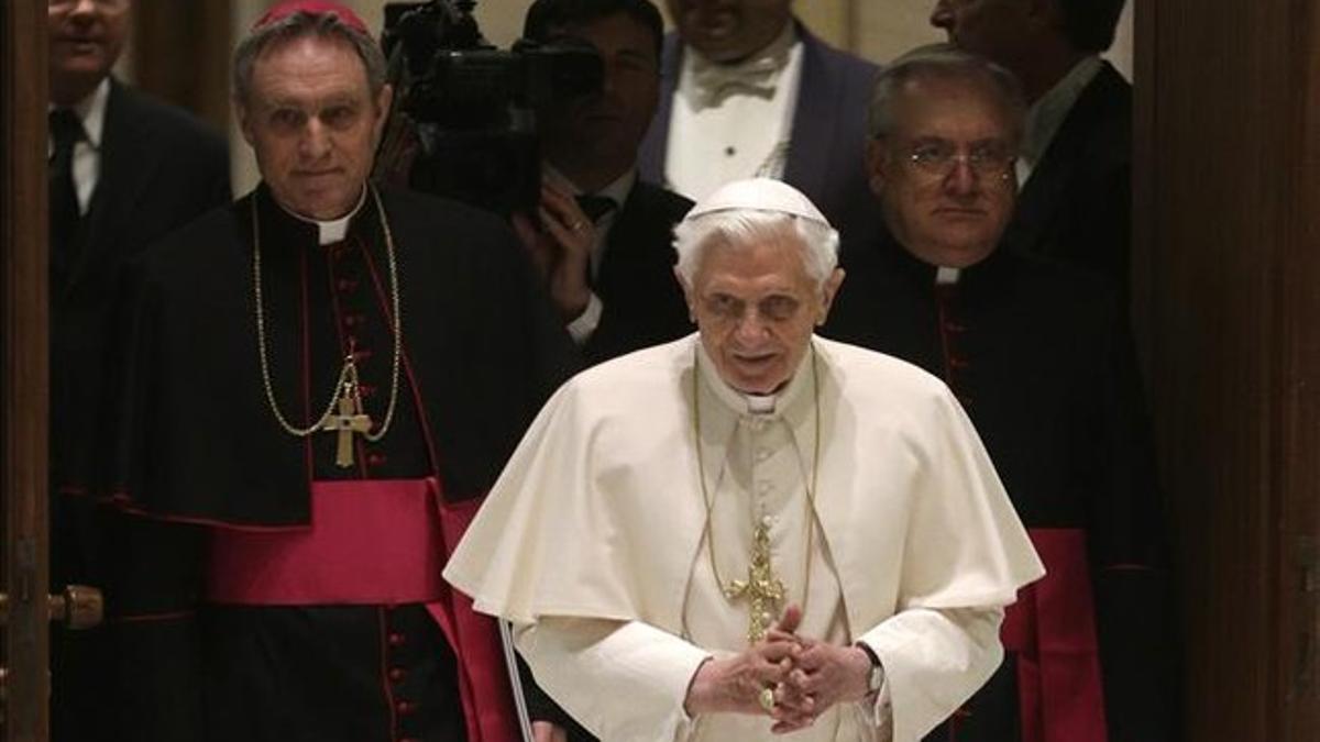 Benedicto XVI llega a la audiencia pública con sus asistentes.